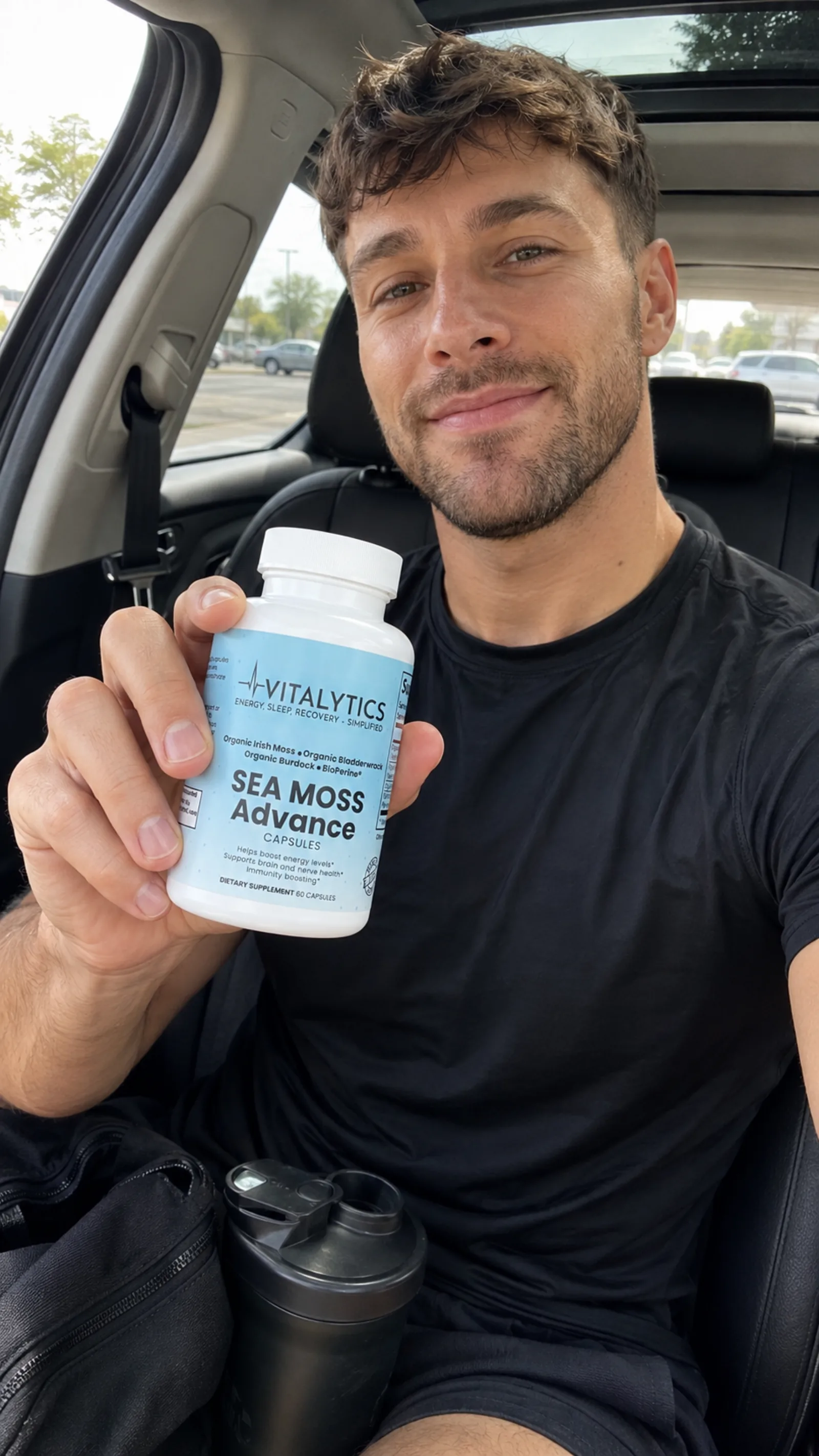Man in a car holding Vitalytics Sea Moss Advance for a casual customer-style selfie.